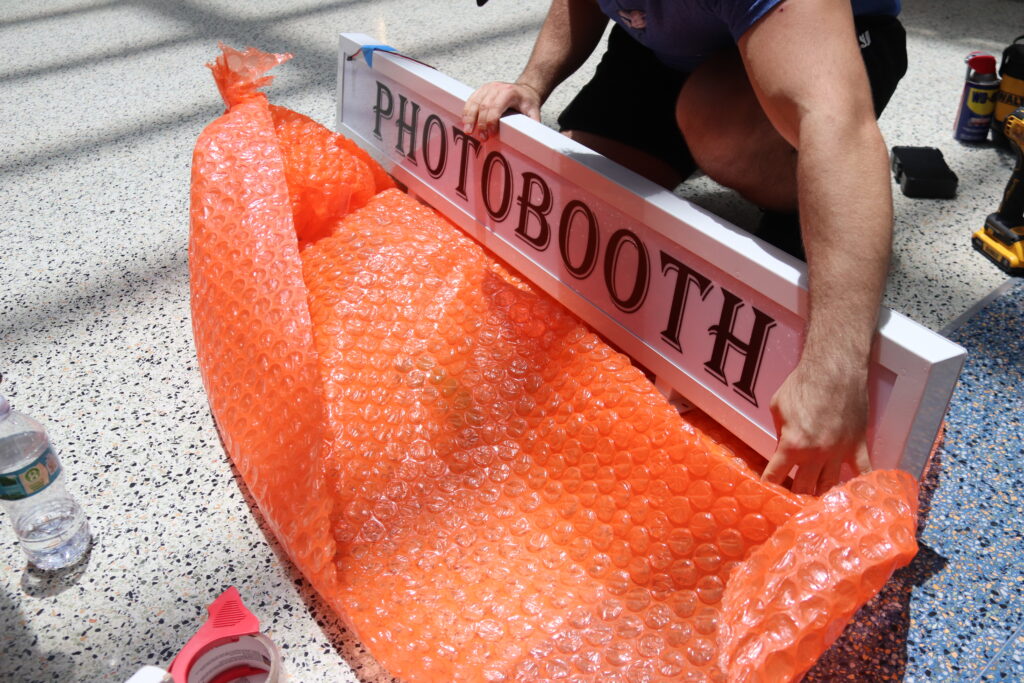 SmileMore marquee sign being unwrapped on the lobby floor during install day