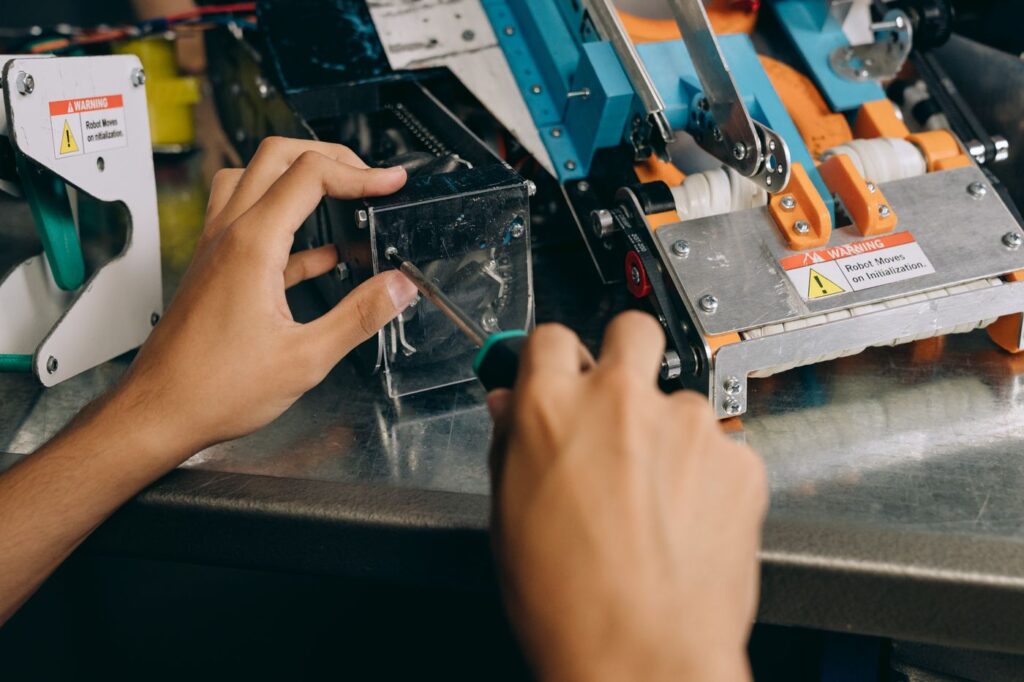 Close up of hands repairing machinery with precision tools during a photo booth repair