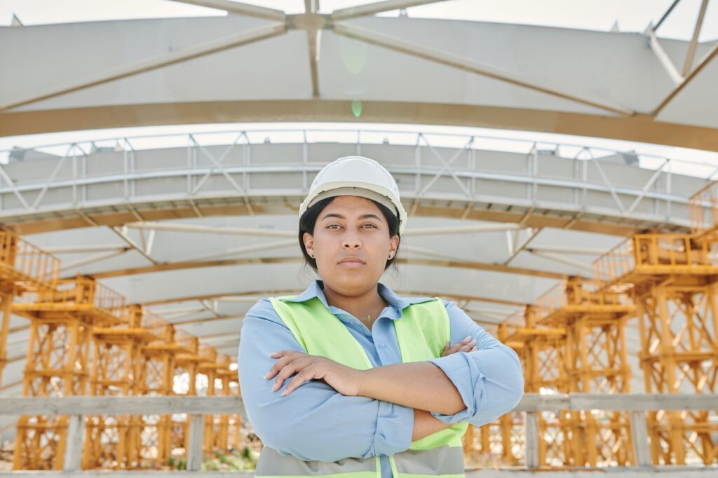 An installer in a hard hat and high visibility vest on a commercial site
