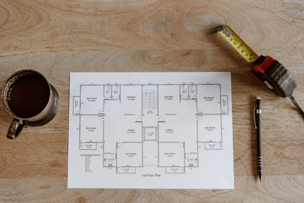 Floor plan, tape measure and pencil on a workbench, used to plan photo booth dimensions in a venue