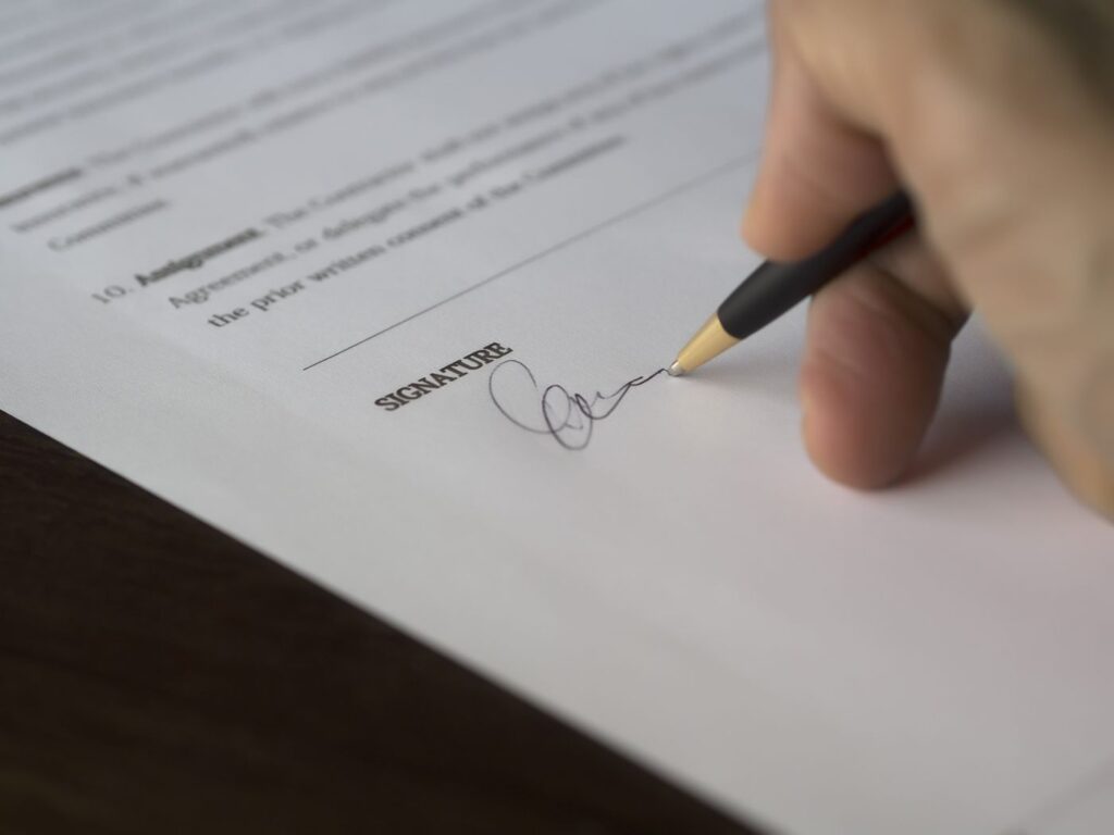 Signing a contract, part of arranging photo booth insurance and placement terms
