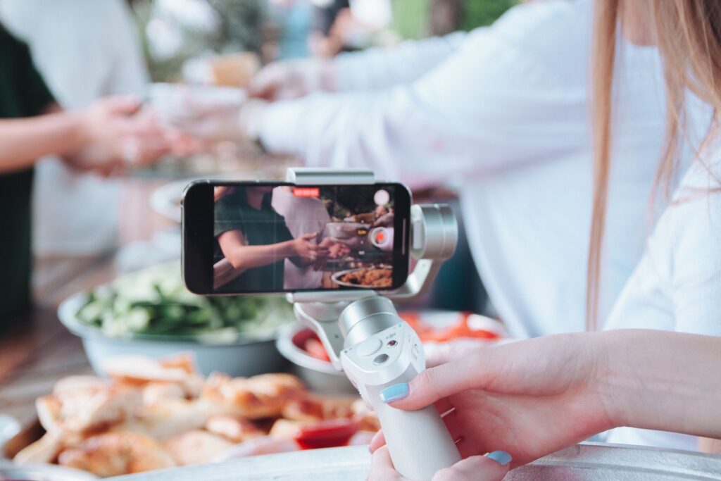 Guest recording a message on a phone at a party, the kind of clip a video guest book photo booth collects