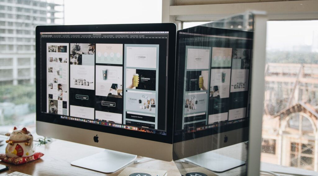 Dual monitors showing design work, the kind of setup used to build custom photo booth software screens