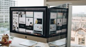Dual monitors showing design work, the kind of setup used to build custom photo booth software screens