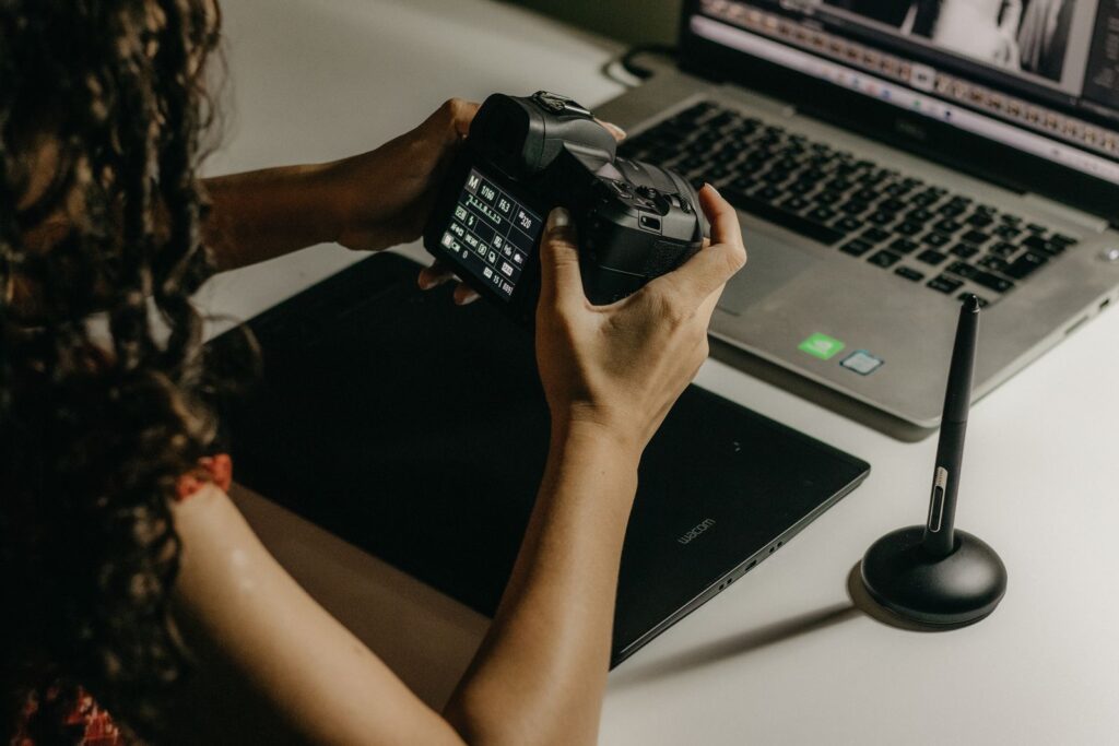 A photographer working between a tablet and a laptop, weighing up a LumaBooth alternative